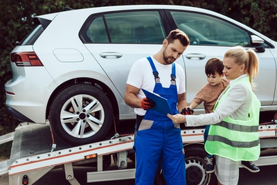 tow truck driver showing mom and child paperwork